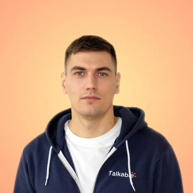 A man in a white tee shirt, with a blue hoodie overtop that has a Talkable logo.