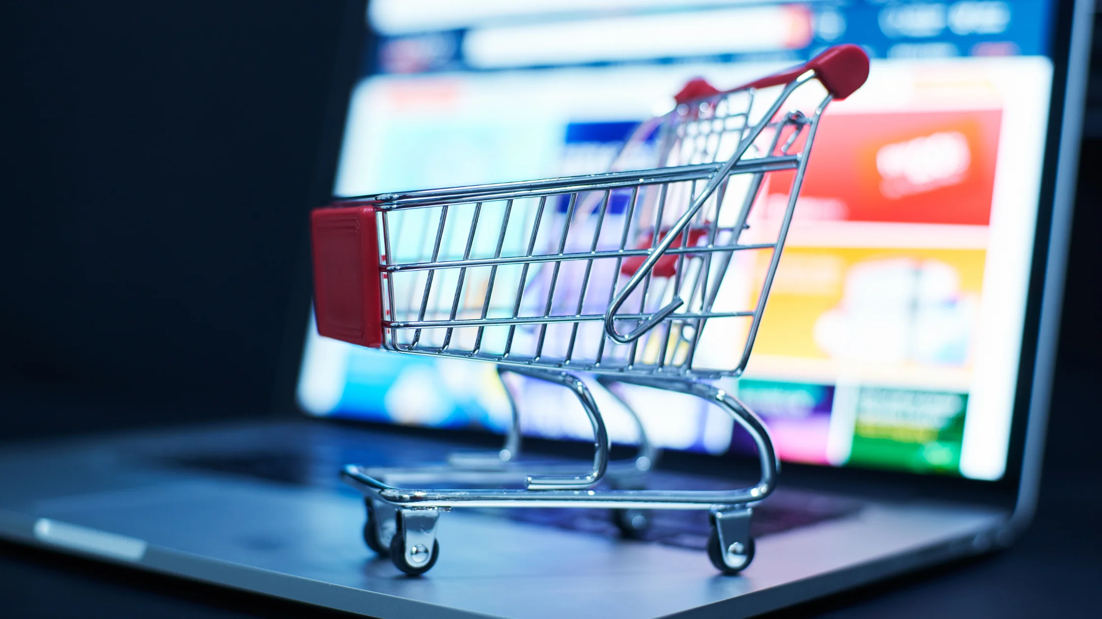 a small shopping cart sitting on a laptop keyboard